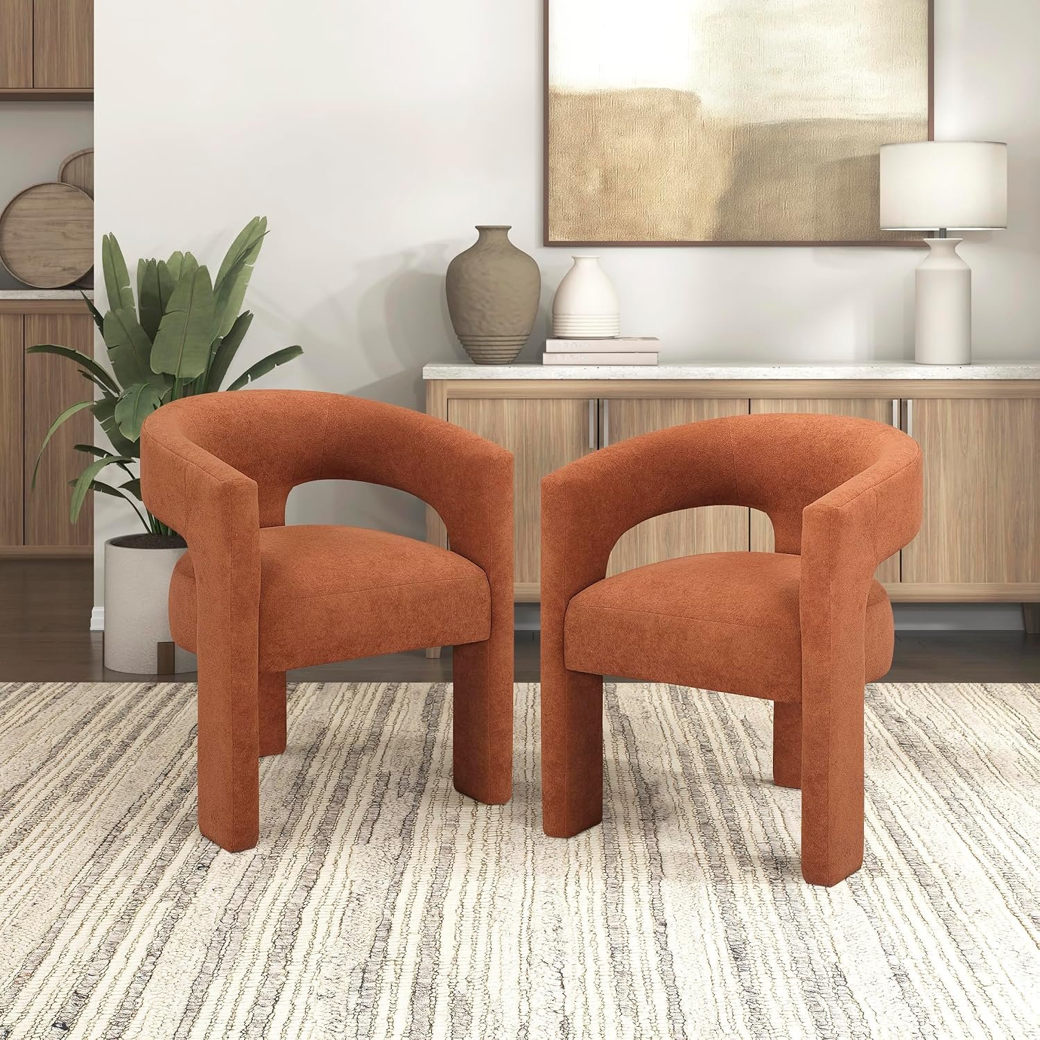 This dining chair is sold in a two-pack, injecting modern energy into your dining room or home office space. The chairs are fully upholstered in a unique boucle velvet fabric with a delicate circular texture, offering a rich feel and durability. The seat and curved backrest are filled with high-density foam for comfortable lumbar support. The chair frame is made of high-quality plywood, molded under high temperature, ensuring structural stability and preventing cracking or deformation. The frame is fully covered in velvet, ensuring both aesthetics and overall sturdiness. The tapered solid wood legs are coated with a protective clear varnish, providing excellent load-bearing capacity and a non-slip, stable feel. The most appealing feature of this chair is that it can be used directly without any tools, offering immediate comfort. The vibrant orange hue easily becomes a visual focal point in any space, suitable for modern minimalist or Scandinavian-style dining tables.